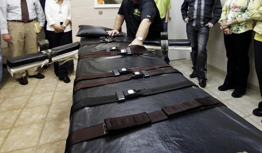 FILE - In this Sept. 18, 2009, file photo, Warden of the Louisiana State Penitentiary, Burl Cain, discusses the gurney used for lethal injections to Ruth Graham, far right and others as they visit the Louisiana State Penitentiary in Angola, La. Louisiana cleans its execution chamber at the state penitentiary daily, but it's been more than a decade since a condemned prisoner has laid on the chamber's black-padded gurney to die. Sixty-eight people sit on Louisiana’s death row, with no execution dates set. Though the state historically has been tough on crime and holds the dubious distinction as the nation's incarceration capital, Louisiana seems to be doing very little to carry out its death penalty. (AP Photo/Judi Bottoni, File)