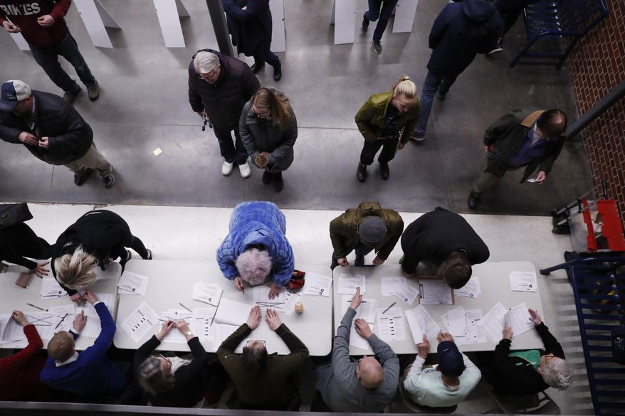 Caucus-goers check-in at a caucus at Roosevelt High School, Monday, Feb. 3, 2020, in Des Moines, Iowa. (AP Photo/Andrew Harnik)