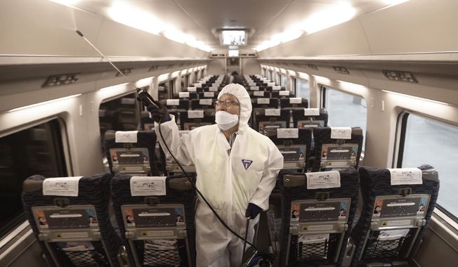 FILE - In this Jan. 24, 2020, file photo, an employee sprays disinfectant on a train as a precaution against a new coronavirus at Suseo Station in Seoul, South Korea. Halting the spread of a new virus that has killed hundreds in China is difficult in part because important details about the illness and how it spreads are still unknown. (AP Photo/Ahn Young-joon, File)