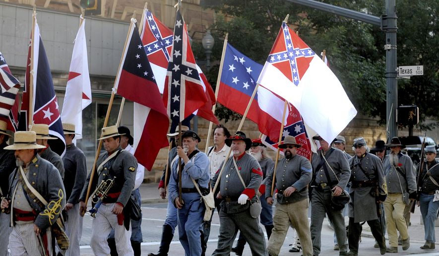 FILE - In this June 3, 2011 file photo, Sons of Confederate Veterans and others march through downtown Shreveport, La., on their way to commemorate Confederate Memorial Day near the Confederate flag and monument in front of Caddo Parish Courthouse. A federal appeals court was set to hear arguments Tuesday, Feb. 4, 2020, over a Louisiana city’s decision to bar the Sons of Confederate Veterans from marching in a 2015 Christmas parade. Court records show the Louisiana Division of the group was denied permission to march in a parade in the city of Natchitoches that year amid concerns that many would be offended by the group carrying a Confederate flag. (Val Horvath Davidson/The Shreveport Times via AP, File)