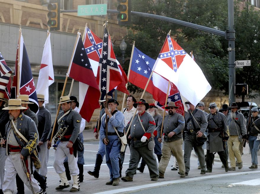 FILE - In this June 3, 2011 file photo, Sons of Confederate Veterans and others march through downtown Shreveport, La., on their way to commemorate Confederate Memorial Day near the Confederate flag and monument in front of Caddo Parish Courthouse. A federal appeals court was set to hear arguments Tuesday, Feb. 4, 2020, over a Louisiana city’s decision to bar the Sons of Confederate Veterans from marching in a 2015 Christmas parade. Court records show the Louisiana Division of the group was denied permission to march in a parade in the city of Natchitoches that year amid concerns that many would be offended by the group carrying a Confederate flag. (Val Horvath Davidson/The Shreveport Times via AP, File)