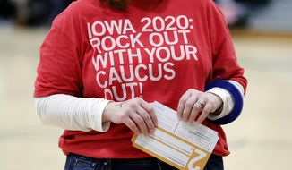 A local resident holds a Presidential Preference Card during an Iowa Democratic caucus at Hoover High School, Monday, Feb. 3, 2020, in Des Moines, Iowa. (AP Photo/Charlie Neibergall)