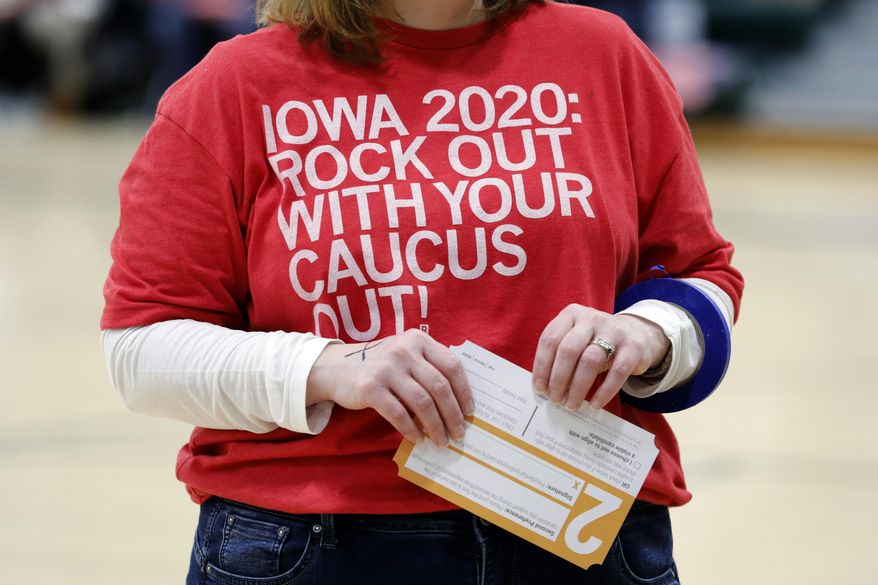 A local resident holds a Presidential Preference Card during an Iowa Democratic caucus at Hoover High School, Monday, Feb. 3, 2020, in Des Moines, Iowa. (AP Photo/Charlie Neibergall)