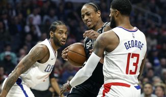 San Antonio Spurs&#39; DeMar DeRozan, center, drives against Los Angeles Clippers&#39; Paul George (13) during the first half of an NBA basketball game, Monday, Feb. 3, 2020, in Los Angeles. (AP Photo/Ringo H.W. Chiu)