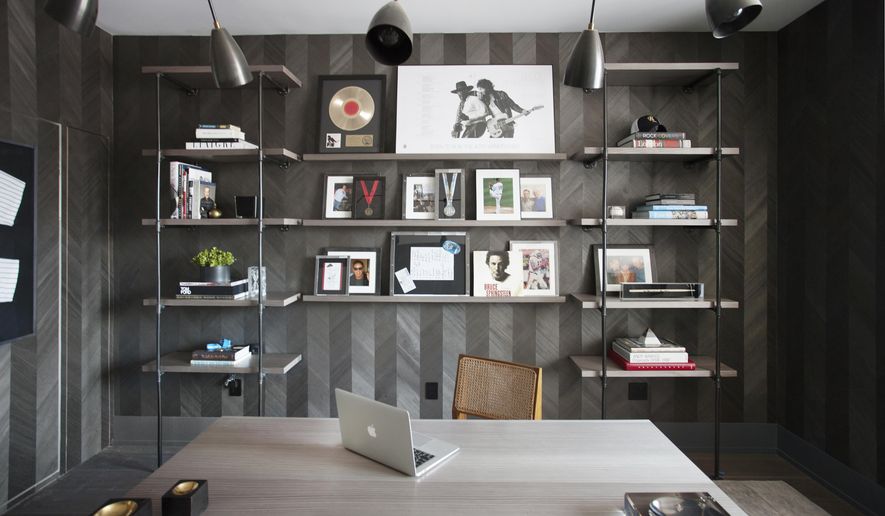 This 2015 photo shows a home office designed by interior designer Michelle Gerson in New York. When one partner has a collection to display and the other partner prefers an uncluttered space, it&#39;s important to take an organized approach, as seen in this home office space created by Gerson, where custom shelving was designed to prominently but neatly display a collection of music memorabilia. (Patrick Cline/Michelle Gerson via AP)