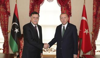 FILE - In this Jan. 12, 2020 file photo, Turkey&#x27;s President Recep Tayyip Erdogan, right, shakes hands with Fayez Sarraj, the head of Libya&#x27;s internationally-recognized government, prior to their meeting in Istanbul. Two Libyan militia commanders and a Syrian war monitor group say Turkey is deploying Syrian extremists to fight in Libya&#x27;s civil war. These extremists are affiliated with groups like al-Qaida and the Islamic State. They&#x27;re fighting as mercenaries on behalf of the United Nations-supported government in Libya. The Libyan sources told The Associated Press that Turkey has airlifted more than 2,500 foreign fighters into Tripoli, and that “dozens” are extremist-affiliated. (Turkish Presidency via AP, Pool, File)