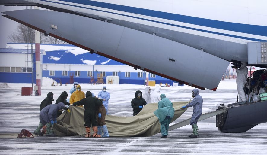 A group of medical personnel prepare to meet 80 people, accompanied by medical specialists, carried by a Russian military plane at an airport outside Tyumen, Russia, Wednesday, Feb. 5, 2020. Russia has evacuated 144 people, Russians and nationals of Belarus, Ukraine and Armenia, from the epicenter of the coronavirus outbreak in Wuhan, China, on Wednesday. All evacuees will be quarantined for two weeks in a sanatorium in the Tyumen region in western Siberia, government officials said. (AP Photo/Maxim Slutsky)
