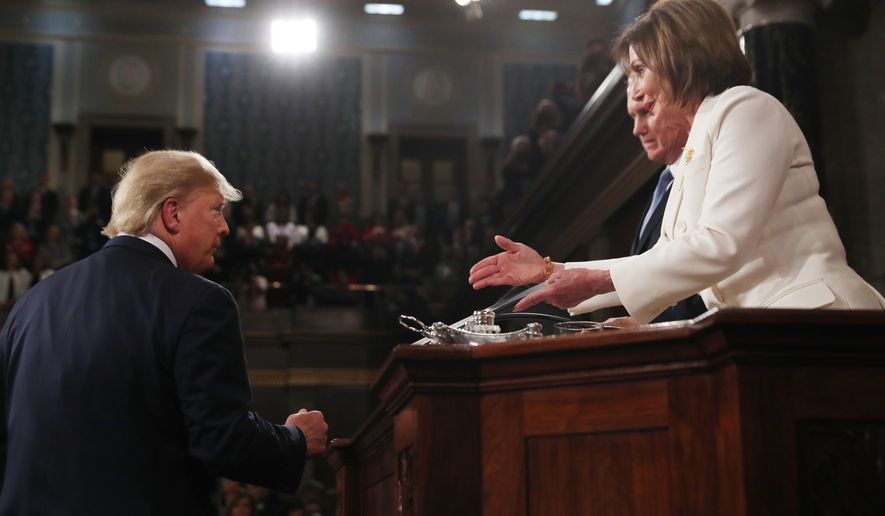 President Donald Trump arrives to deliver his State of the Union address to a joint session of Congress in the House Chamber on Capitol Hill in Washington, Tuesday, Feb. 4, 2020, as Speaker Nancy Pelosi reaches to shake his hand. (Leah Millis/Pool via AP)