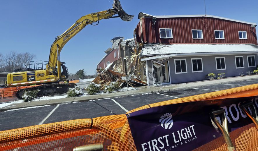 FILE - In this April 5, 2016, file photo, an excavator demolishes a building during an official groundbreaking Taunton, Mass., where the Mashpee Wampanoag tribe was to build the First Light Resort & Casino. The project was halted shortly afterward when a group of residents sued, arguing the federal government couldn't take the land into trust for the tribe. A federal appeals court in Boston is hearing arguments Wednesday, Feb. 5, 2020, in the ongoing dispute. (AP Photo/Elise Amendola, File)