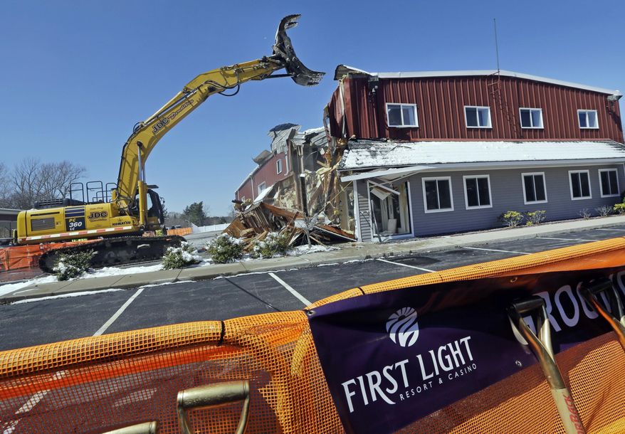 FILE - In this April 5, 2016, file photo, an excavator demolishes a building during an official groundbreaking Taunton, Mass., where the Mashpee Wampanoag tribe was to build the First Light Resort & Casino. The project was halted shortly afterward when a group of residents sued, arguing the federal government couldn't take the land into trust for the tribe. A federal appeals court in Boston is hearing arguments Wednesday, Feb. 5, 2020, in the ongoing dispute. (AP Photo/Elise Amendola, File)