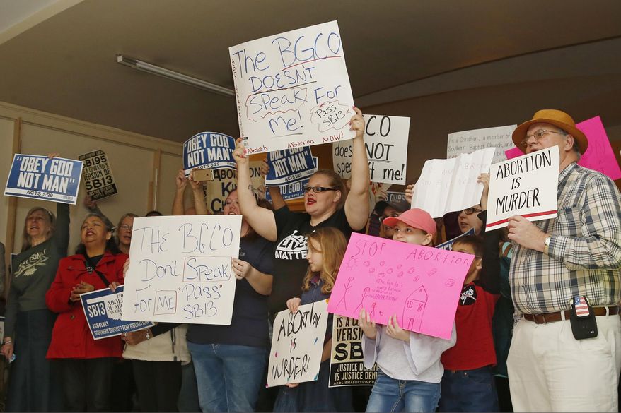 FILE - In this Monday, Feb. 25, 2019 file photo, abortion opponents cheer for a speaker at a rally at the state Capitol in Oklahoma City. The Oklahoma House approved a bill on Thursday, Feb. 6, 2020, to suspend the medical license of any doctors who perform abortions, setting up a likely court challenge if the measure is signed into law.(AP Photo/Sue Ogrocki, File)