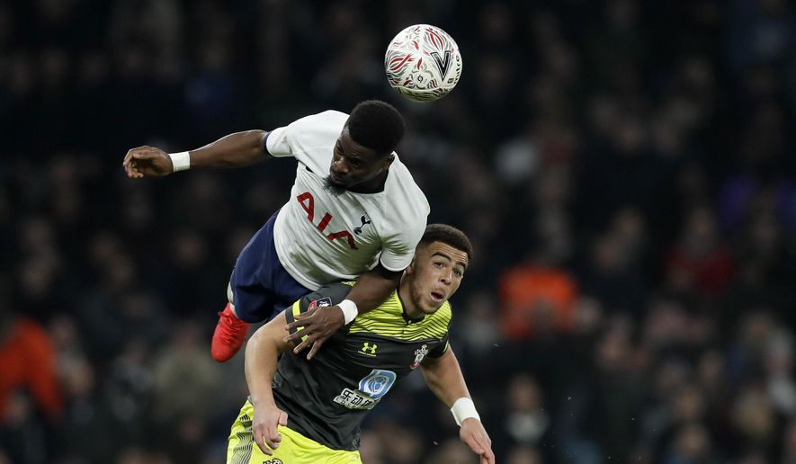 Tottenham's Tanguy Ndombele heads the ball above Southampton's Jan Bednarek, right, during the English FA Cup fourth round replay soccer match between Tottenham Hotspur and Southampton at the Tottenham Hotspur Stadium in London, Wednesday, Feb. 5, 2020. (AP Photo/Kirsty Wigglesworth)