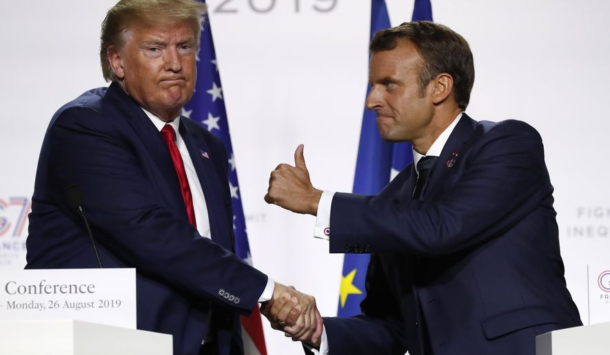 FILE - In this Aug. 26, 2019, file photo, French President Emmanuel Macron and U.S President Donald Trump shake hands during the final press conference during the G7 summit in Biarritz, southwestern France. Famously muscular white-knuckle handshakes between Trump and Macron have served as metaphors for a difficult and turbulent relationship. (AP Photo/Francois Mori, File)