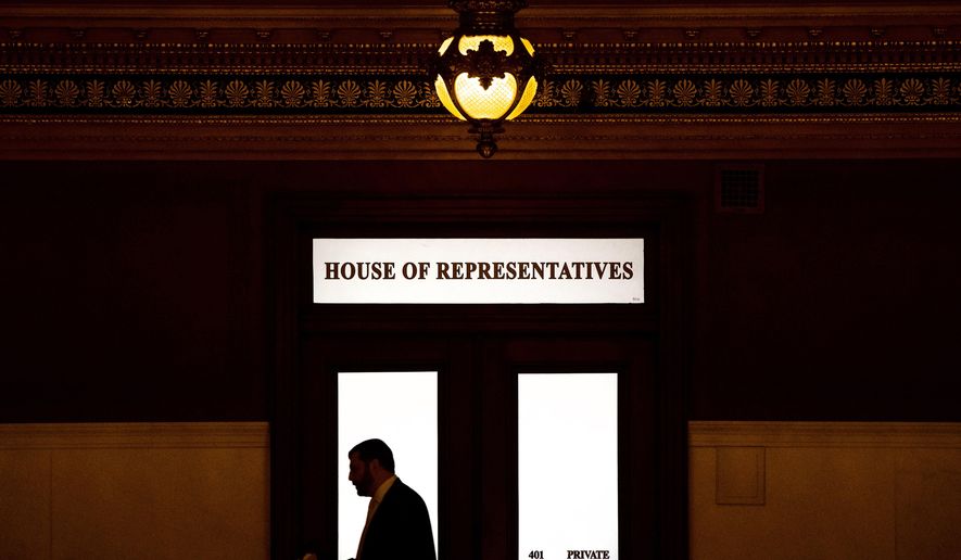 FILE - In this Nov. 20, 2019 file photo, a lawmaker is silhouetted as he walks past a window in the Pennsylvania Capitol in Harrisburg, Pa. While most states have not yet considered law changes to screen former clergy members who seek licenses for jobs that put them in contact with children, at least 20 state attorneys general are conducting investigations of how church officials handled abuse allegations, including reporting them to civil law enforcement, largely in the wake of the Pennsylvania attorney general office’s 2018 grand jury report that looked at how abuse allegations were handled in six dioceses. (AP Photo/Matt Rourke, File)