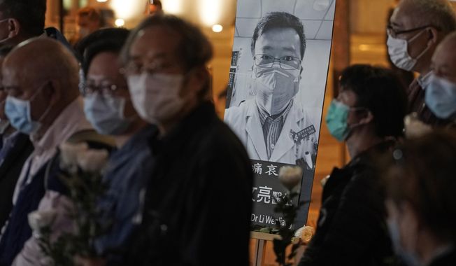 People wearing masks, attend a vigil for Chinese doctor Li Wenliang, in Hong Kong, Friday, Feb. 7, 2020. The death of a young doctor who was reprimanded for warning about China&#x27;s new virus triggered an outpouring Friday of praise for him and fury that communist authorities put politics above public safety. (AP Photo/Kin Cheung)