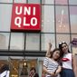 FILE - In this July 16, 2015, file photo, Chinese women take a selfie outside the Uniqlo flagship store in Beijing. Fast Retailing Co., parent of Uniqlo fashion chain, said it has temporarily closed about half of its 750 outlets in mainland China due to the outbreak of a new virus. (AP Photo/Ng Han Guan, File)