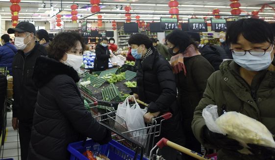 People wearing masks buy foods at a supermarket in Hangzhou in east China&#39;s Zhejiang province, Saturday, Feb. 8, 2020. China&#39;s communist leaders are striving to keep food flowing to crowded cities despite anti-disease controls, to quell fears of possible shortages and stave off price spikes from panic buying after most access to Wuhan was cut off Jan. 23. Food stocks in supermarkets ran low shortly after Beijing imposed travel curbs and extended the Lunar New Year holiday to keep factories, offices and other businesses closed and the public at home, attempting to prevent the virus from spreading. (Chinatopix via AP)