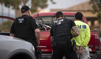 In this July 8, 2019, photo, a U.S. Immigration and Customs Enforcement (ICE) officers detain a man during an operation in Escondido, Calif. (AP Photo/Gregory Bull) ** FILE **