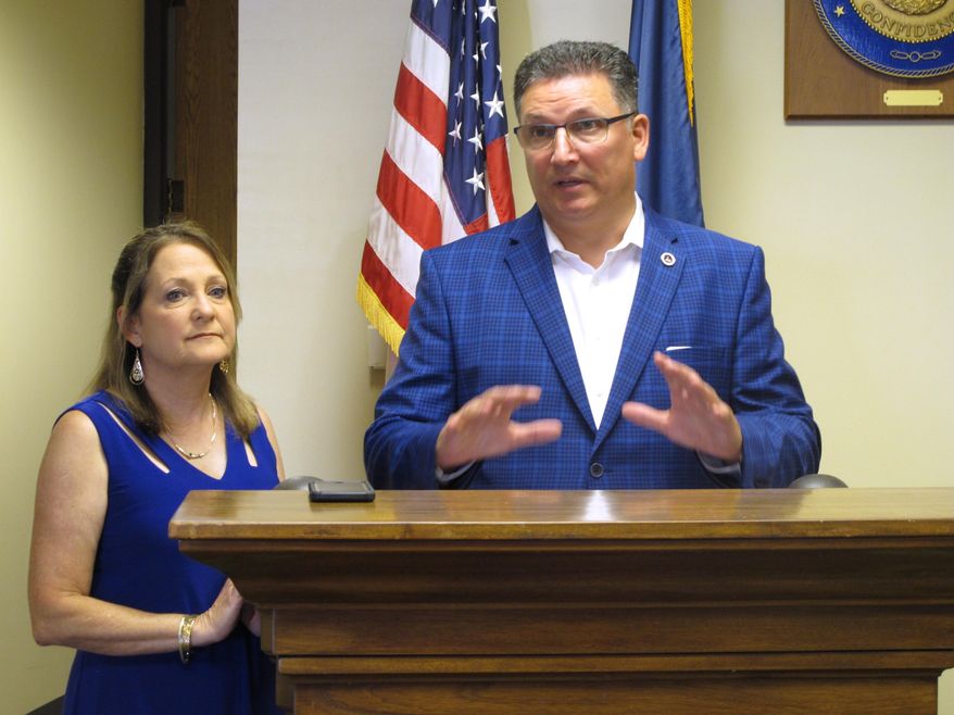 FILE - In this Aug. 7, 2019 file photo, Treasurer John Schroder speaks after qualifying for his re-election bid, joined by his wife Ellie in Baton Rouge, La.   Gov. John Bel Edwards is suing Louisiana's state treasurer for blocking a $25 million fund transfer the governor and lawmakers earmarked for state operating expenses.  (AP Photo/Melinda Deslatte, File)