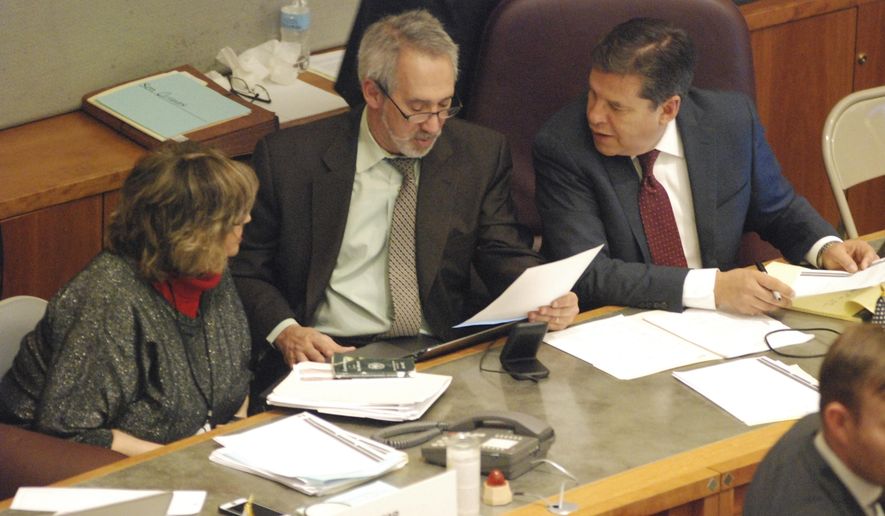 Three sponsors of red flag gun legislation confer during a floor debate at the New Mexico state Senate on Friday, Feb. 7, 2020. They are Sen. Joseph Cervantes, D-Las Cruces, right, and Reps. Daymon Ely, center, D-Corrales, and Joy Garratt, left, D-Albuquerque. The gun proposal would allow law enforcement officers to petition a state district court to order the temporary surrender of firearms by people who appear to pose a danger to themselves or others. (AP Photo/Morgan Lee)