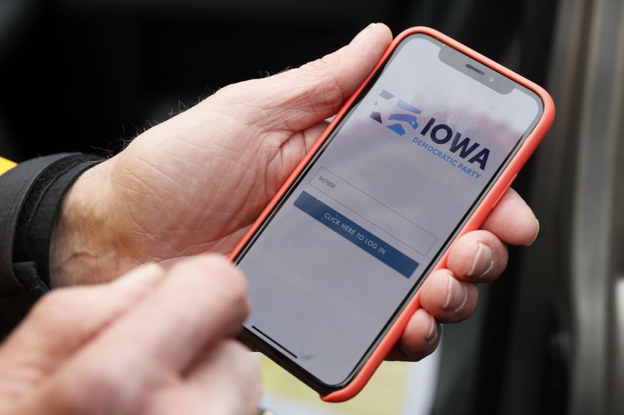 FILE - In this Friday, Nov. 15, 2019 file photo, a precinct captain from Des Moines, Iowa, holds his iPhone that shows the Iowa Democratic Party's caucus reporting app. On Friday, Feb. 7, 2020, The Associated Press reported on stories circulating online incorrectly asserting that federal records show George Soros is the biggest funder of the failed app used by the Iowa Democratic Party during Monday’s caucuses. The chart used in the assertion does not show a donation by Soros to Shadow Inc. Instead, the chart, which was published in a November 2019 story on the investigative news site Sludge, shows Soros gave $2.6 million to the National Democratic Redistricting Committee, a Democratic Party-aligned organization focused on legislative redistricting. (AP Photo/Charlie Neibergall)