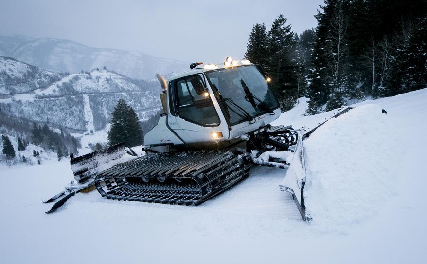 Jerry Hill grooms a run in a snowcat while he inspects the mountain before Sundance Mountain Resort opens Thursday, Jan. 30, 2020, in Provo Canyon near Provo, Utah. "The views never get old," said Hill. "There are always great views, and then there's the great, great views when the sunlight is just right, and the evening light too. I'm pretty lucky that way." (Isaac Hale/The Daily Herald via AP)