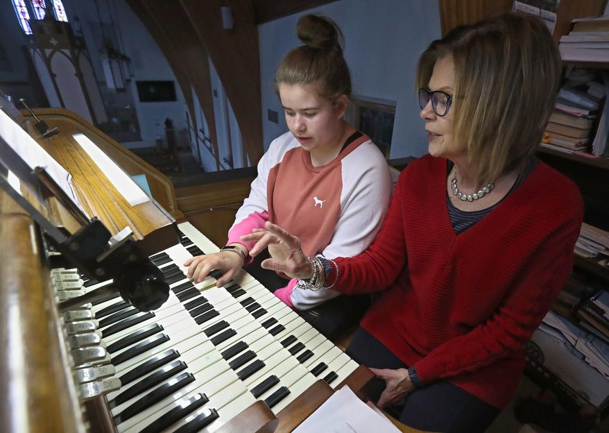 ADVANCE FOR PUBLICATION ON SATURDAY, FEB. 8, AND THEREAFTER - In a Jan. 28, 2020, photo, Sonya Kempf, right, helps her granddaughter Zoe with her fingering as she plays the organ at Zion Lutheran Church, in Aberdeen, S.D. Music mentor Kempf has played at Zion Lutheran for 50 years. ( John Davis/Aberdeen American News via AP)