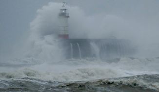Waves crash over the harbour and a lighthouse, as Storm Ciara hits Newhaven, on the south coast of England, Sunday, Feb. 9, 2020. Trains, flights and ferries have been cancelled and weather warnings issued across the United Kingdom and in northern Europe as the storm with winds expected to reach hurricane levels batters the region. (AP Photo/Matt Dunham)