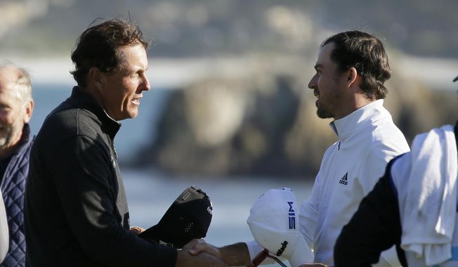 Nick Taylor, right, of Canada, is greeted by Phil Mickelson on the 18th green of the Pebble Beach Golf Links after winning the AT&amp;amp;T Pebble Beach National Pro-Am golf tournament Sunday, Feb. 9, 2020, in Pebble Beach, Calif. (AP Photo/Eric Risberg)