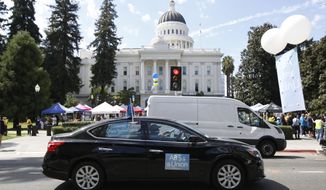 FILE — In this Aug. 28, 2019 file photo supporters of a measure to limit when companies can label workers as independent contractors circle the Capitol during a rally in Sacramento, Calif. U.S. District Judge Dolly Gee denied a request by ride-share company Uber and on-demand a request delivery service Postmates for a preliminary injunction protecting them from the new law aimed at giving protections to people who work as independent contractors, Monday, Feb.10, 2020. (AP Photo/Rich Pedroncelli, File)