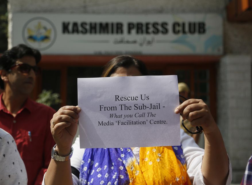 FILE- In this Oct. 3, 2019 file photo, Kashmiri journalists displays a placard during a protest against the communication blackout in Srinagar, Indian controlled Kashmir. Journalists in disputed Kashmir urged the Indian government on Monday to allow them to report freely and expressed concern about alleged police harassment since the region’s semi-autonomy was rescinded in August amid an unprecedented lockdown. (AP Photo/Mukhtar Khan, File)