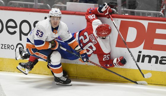 Washington Capitals center Nic Dowd (26) collides into the boards next to New York Islanders center Casey Cizikas (53) during the first period of an NHL hockey game, Monday, Feb. 10, 2020, in Washington. (AP Photo/Nick Wass) ** FILE **