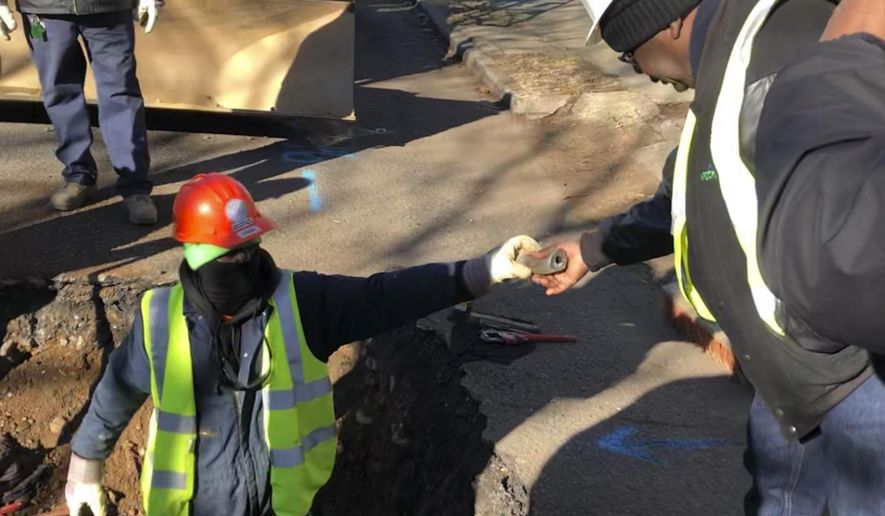 File – In this Thursday, Jan. 9, 2020 file photo, a worker hands a piece of lead pipe to a colleague as they work to remove water service lines in Trenton, N.J. New Jersey water systems must cut the time they notify residents about elevated lead levels from 60 days to 10 days under a bill the Democrat-led Senate is scheduled to vote on Monday, Feb. 10, 2020. (AP Photo/Mike Catalini, File)