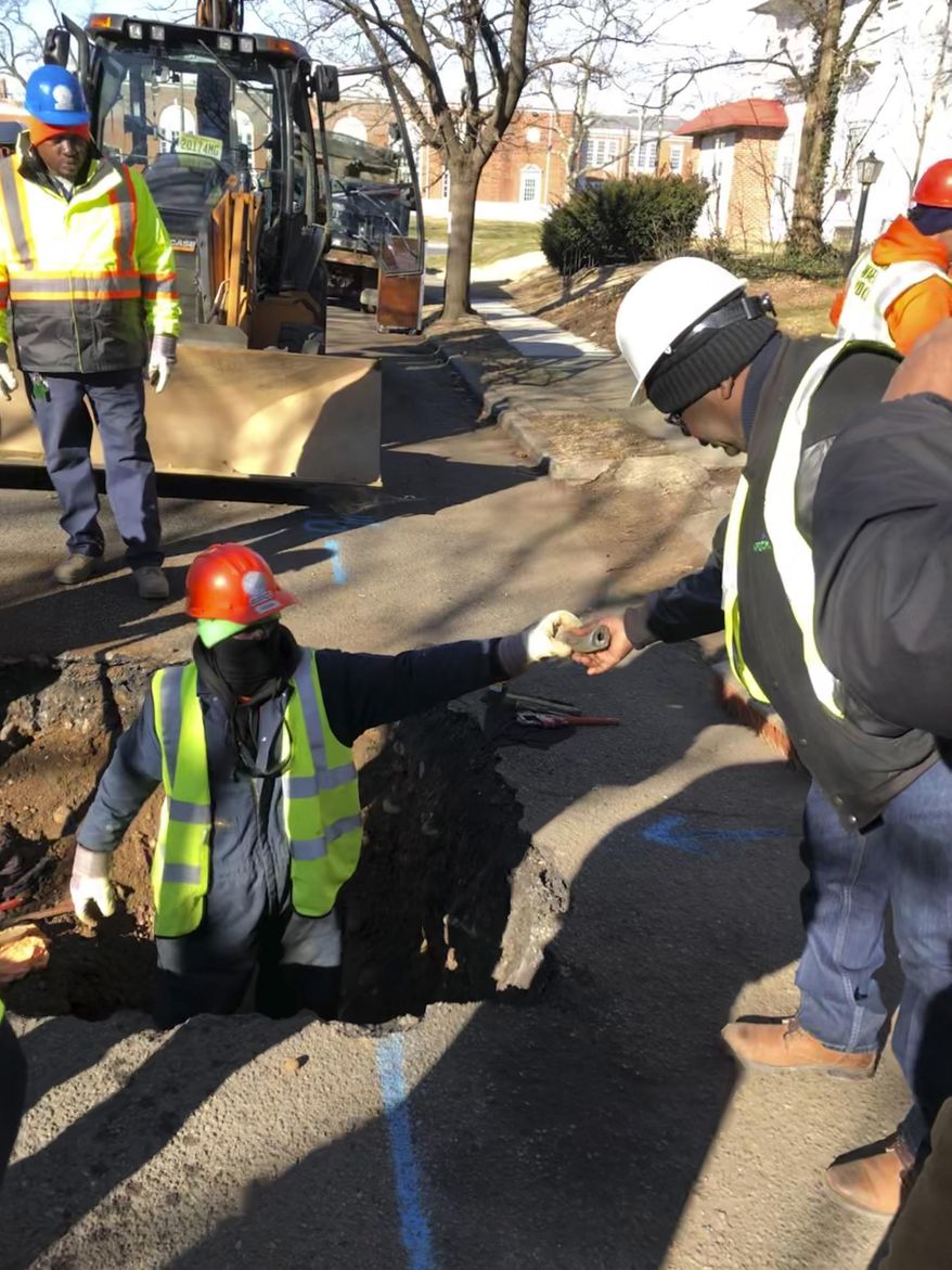 File – In this Thursday, Jan. 9, 2020 file photo, a worker hands a piece of lead pipe to a colleague as they work to remove water service lines in Trenton, N.J. New Jersey water systems must cut the time they notify residents about elevated lead levels from 60 days to 10 days under a bill the Democrat-led Senate is scheduled to vote on Monday, Feb. 10, 2020. (AP Photo/Mike Catalini, File)