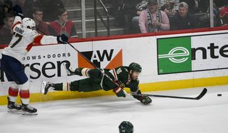 Florida Panthers left wing Frank Vatrano, left, gets a two minute penalty as he trips Minnesota Wild winger Jason Zucker during the third period of an NHL hockey game Monday, Jan. 20, 2020, in St. Paul, Minn. The Panthers won 5-4. (AP Photo/Craig Lassig)