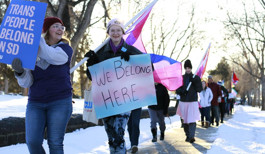 Protesters march outside the South Dakota Capitol in Pierre on Monday, Feb. 10, 2020, as LGBT advocates protested a bill that would ban gender conformation medical treatments for children under 16. (AP Photo/Stephen Groves)