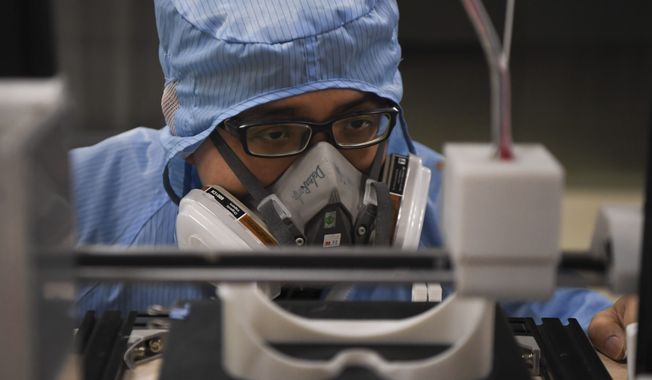 In this photo released by Xinhua News Agency, a worker inspects the operation of a 3D printer at the additive manufacturing research and application center of the Hunan Vanguard Group Co., Ltd. in the economic development zone of Changsha city in central China&#x27;s Hunan Province, on Tuesday, Feb. 11, 2020. The company has been producing goggles for medical use with more than 50 3D printers working day and night for use in hospital fighting the novel coronavirus outbreak. (Xue Yuge/Xinhua via AP) NO SALES