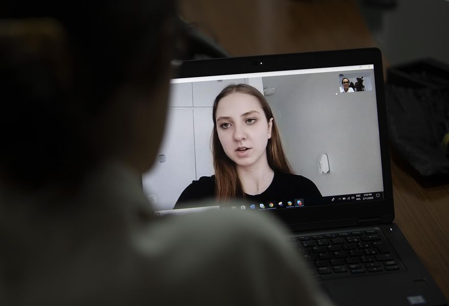 Adrielly Eger gives a video interview from the Anapolis airbase in Annapolis, Goias state, where she is in quarantine with others, as she gives an interview to the A.P. in Rio de Janeiro, Brazil, Tuesday, Feb. 11, 2020. For the next two weeks, the Brazilian model and 33 other individuals repatriated from China on Sunday will be staying at the Anapolis airbase, in the Brazilian state of Goias. (AP Photo/Silvia Izquierdo)