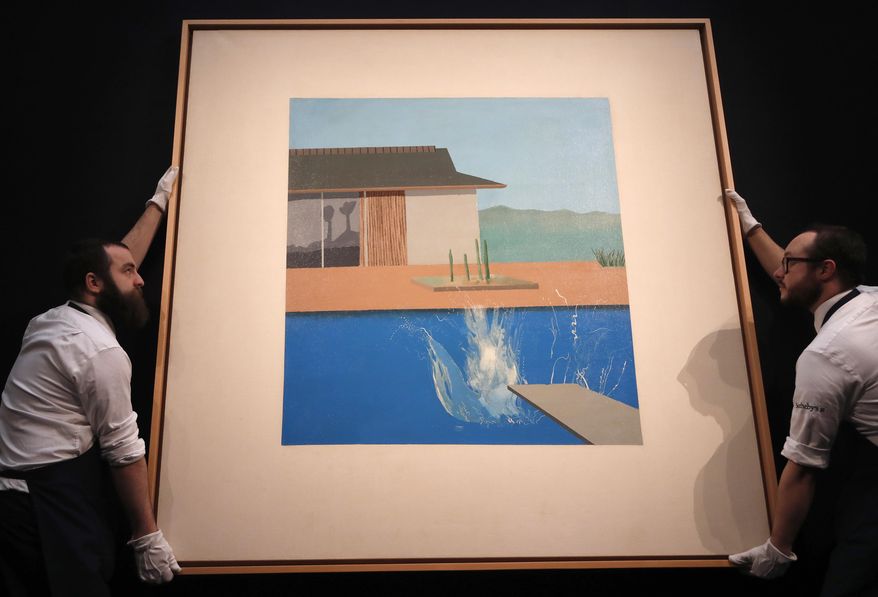 Two Sotheby's employees adjust David Hockney's painting 'The Splash' at Sotheby's contemporary Art sale preview in London, Friday, Feb. 7, 2020. The Contemporary Art Auction will take place on evening of February 11 where 'The Splash' is estimated at 20-30 million GBP, 25-38 million USD. (AP Photo/Frank Augstein)