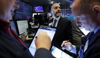 FILE - In this Feb. 6, 2020, file photo specialist Meric Greenbaum, center, works with traders at his post on the floor of the New York Stock Exchange.  The U.S. stock market opens at 9:30 a.m. EST on Tuesday, Feb. 11. (AP Photo/Richard Drew, File)