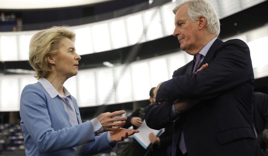European Commission President Ursula von der Leyen, left, talks to to European Union chief Brexit negotiator Michel Barnier during a debate on a proposed mandate for negotiations for a new partnership with the United Kingdom of Great Britain and Northern Ireland, at the European Parliament in Strasbourg, eastern France, Tuesday, Feb.11, 2020. (AP Photo/Jean-Francois Badias)