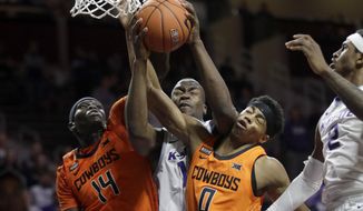 Kansas State forward Makol Mawien, middle, rebounds against Oklahoma State forward Yor Anei (14) and guard Avery Anderson III (0) during the second half of an NCAA college basketball game in Manhattan, Kan., Tuesday, Feb. 11, 2020. Oklahoma State defeated Kansas State 64-59. (AP Photo/Orlin Wagner)