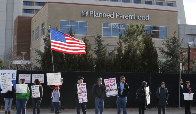 In this Feb. 11, 2017, file photo, pro-choice counterprotesters hold signs supporting a woman&#x27;s right to choose abortion, as nearby anti-abortion activists held a rally in front of Planned Parenthood of the Rocky Mountains, in Denver. (AP Photo/Brennan Linsley, File)
