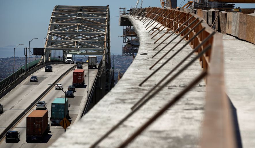 In this July 2, 2018, file photo, traffic moves on the old Gerald Desmond Bridge next to its replacement bridge under construction in Long Beach, Calif. (AP Photo/Jae C. Hong, File)