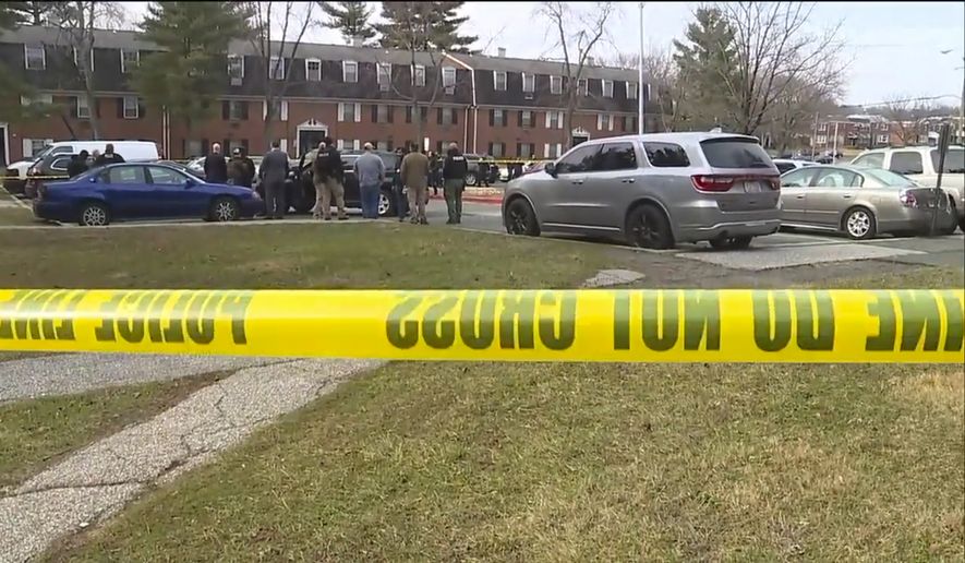 This image provided by WMAR-2 News shows emergency and law enforcement officials responding to the scene of a shooting, Wednesday, Feb. 12, 2020, in Baltimore. Two law enforcement officers with a fugitive task force were injured and a suspect died in a shooting on Wednesday, the U.S. Marshals Service said. (WMAR-2 News via AP)