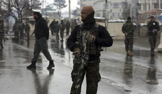 National army soldiers stand guard at the site of suicide attack near the military academy in Kabul, Afghanistan, Tuesday, Feb. 11, 2020. A suicide bomber targeting a military academy in the Afghan capital on Tuesday killed at least six people, including two civilians and four military personnel, the Interior Ministry said. (AP Photo/Rahmat Gul)