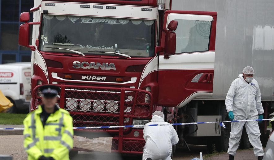 FILE - In this file photo dated Wednesday Oct. 23, 2019, Police forensic officers attend the scene after a truck was found to contain a large number of dead bodies, in Grays, South England. Police said Tuesday Feb. 11, 2020, that a provisional postmortem examination of 39 bodies found inside this shipping container in England concluded that the victims from Vietnam died of a combination of insufficient oxygen and overheating in a closed space. Police said Feb. 11, they are continuing to make progress in a complex investigation. (AP Photo/Alastair Grant, FILE)