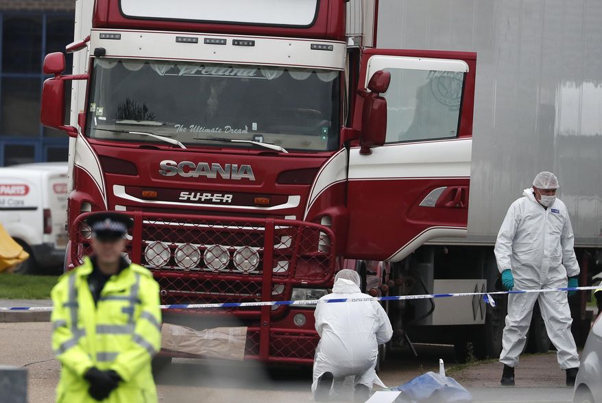 FILE - In this file photo dated Wednesday Oct. 23, 2019, Police forensic officers attend the scene after a truck was found to contain a large number of dead bodies, in Grays, South England. Police said Tuesday Feb. 11, 2020, that a provisional postmortem examination of 39 bodies found inside this shipping container in England concluded that the victims from Vietnam died of a combination of insufficient oxygen and overheating in a closed space. Police said Feb. 11, they are continuing to make progress in a complex investigation. (AP Photo/Alastair Grant, FILE)