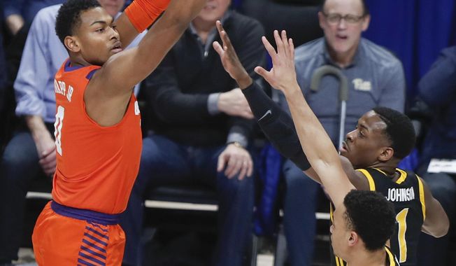 Clemson&#x27;s Clyde Trapp shoots over Pittsburgh&#x27;s Xavier Johnson (1) and Trey McGowens during the first half of an NCAA college basketball game Wednesday, Feb. 12, 2020, in Pittsburgh. (AP Photo/Keith Srakocic)