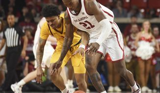 Oklahoma forward Kristian Doolittle (21) tries to steal the ball from Iowa State Prestiss Nixon (11) during the second half of an NCAA college basketball game in Norman, Okla., Wednesday, Feb. 12, 2020. (AP Photo/Kyle Phillips)